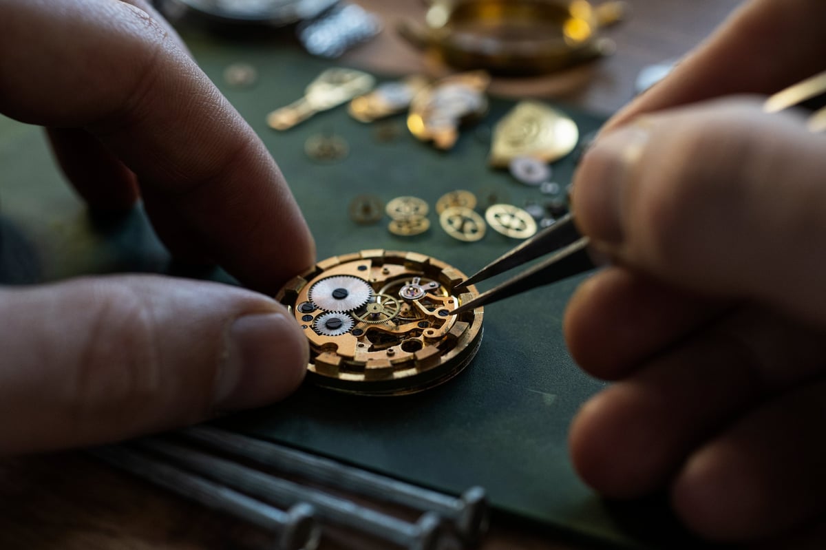 Watchmaker repairing mechanical watches with precision tools